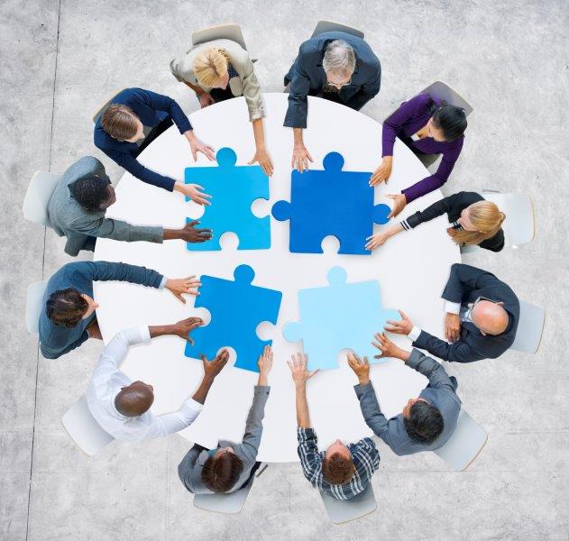 Individuals meeting around a table to form a team