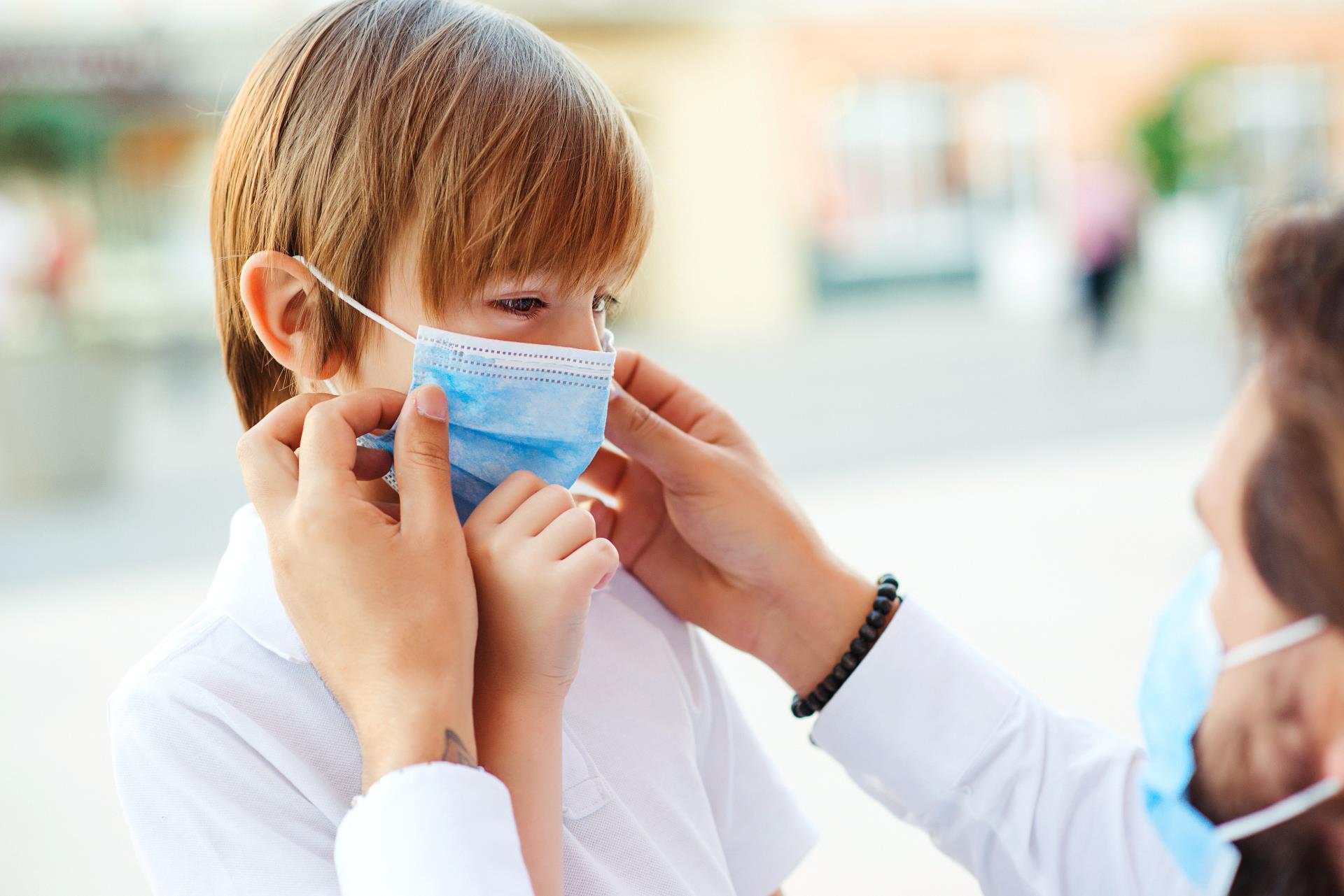 Father assisting child with face mask