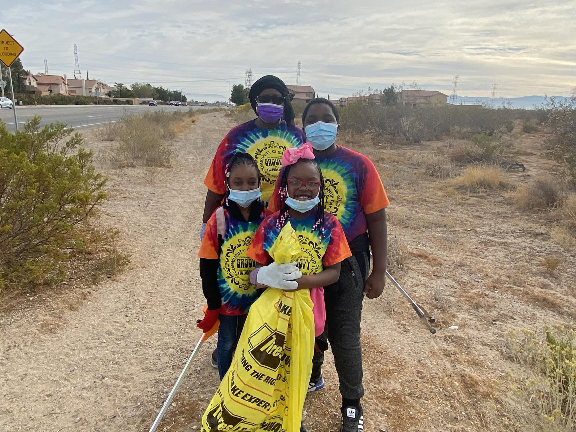 ShaBazz Family posed with a bag of collected litter